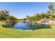 Beautiful view of the lake with a waterfall, lush greenery and mature trees surrounding its clear water at 2744 E Donato Dr, Gilbert, AZ 85298