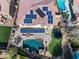 Aerial view of the home features a large roof with solar panels, a pool, and luscious green landscaping at 2829 W Haley Dr, Anthem, AZ 85086