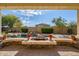 A covered patio with a stone fire pit and a beautiful view of the pool and landscaped backyard at 2829 W Haley Dr, Anthem, AZ 85086