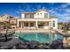 Inviting backyard featuring a sparkling pool with a rock waterfall and a covered patio at 2829 W Haley Dr, Anthem, AZ 85086