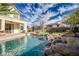 Gorgeous backyard pool features rock features and a beautiful blue sky at 2829 W Haley Dr, Anthem, AZ 85086
