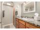 Bathroom with wood cabinets, granite countertop, and a decorative mirror over the sink at 3226 E Lazy Ln, Phoenix, AZ 85028