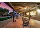 Inviting covered patio with rocking chairs overlooking the landscaped backyard and pool area at 3226 E Lazy Ln, Phoenix, AZ 85028