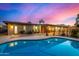 Stunning backyard with a pool, covered patio, and well-maintained landscaping under the evening sky at 3226 E Lazy Ln, Phoenix, AZ 85028