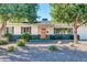Charming home featuring xeriscape landscaping, mature shade trees, and a vibrant coral colored front door at 3326 N 82Nd Pl, Scottsdale, AZ 85251
