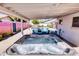 Covered outdoor hot tub and patio featuring a pool and outdoor dining area in the background at 3326 N 82Nd Pl, Scottsdale, AZ 85251