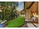 An inviting backyard with an artificial putting green, covered patio, and views of the surrounding desert landscape at 3500 E Lincoln Dr # 6, Phoenix, AZ 85018