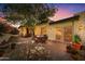 Charming patio with brick pavers, dining set, and lush landscaping for relaxing outdoors at sunset at 3500 E Lincoln Dr # 6, Phoenix, AZ 85018