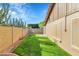 Wide backyard with grass area, brick-lined features, desert plants, and block fence at 3523 W Kelton Ln, Phoenix, AZ 85053