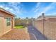 Fenced backyard with a water feature, rock landscaping, and glimpses of the surrounding neighborhood at 3523 W Kelton Ln, Phoenix, AZ 85053