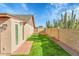 Grassy backyard featuring block wall, plants, and a glimpse of the home's exterior at 3523 W Kelton Ln, Phoenix, AZ 85053