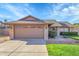 Single-story brick home featuring a well-manicured lawn, mature shrubs, and a two-car garage at 3523 W Kelton Ln, Phoenix, AZ 85053