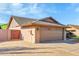 Side view of a brick house showcasing the two-car garage, desert landscaping, and a block wall at 3523 W Kelton Ln, Phoenix, AZ 85053