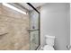 Walk-in shower featuring glass door, travertine tile, and a shower head at 3523 W Kelton Ln, Phoenix, AZ 85053