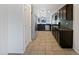 Modern kitchen featuring stainless steel appliances, dark wood cabinets, and tile flooring at 40995 W Portis Dr, Maricopa, AZ 85138