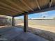 Covered patio view, with neutral color block fencing surrounding the spacious dirt backyard at 4124 E Apollo Rd, Phoenix, AZ 85042