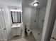 Bright bathroom with tiled walk-in shower, white vanity, and a dark framed mirror at 4124 E Apollo Rd, Phoenix, AZ 85042