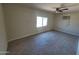 An empty bedroom with gray-brown tiled floors, and a window with natural light shining through at 4124 E Apollo Rd, Phoenix, AZ 85042