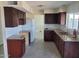 Kitchen featuring dark wood cabinets, granite countertops, white subway tile backsplash, and stainless steel sink at 4124 E Apollo Rd, Phoenix, AZ 85042