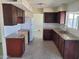 Kitchen featuring dark wood cabinets, granite countertops, white subway tile backsplash, and stainless steel sink at 4124 E Apollo Rd, Phoenix, AZ 85042