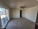 Large living room with sliding glass doors, gray-brown tile floors, and ceiling fan at 4124 E Apollo Rd, Phoenix, AZ 85042