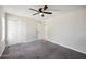 Bedroom with gray carpet, closet, ceiling fan, and white door at 4737 E Belleview St, Phoenix, AZ 85008