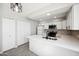 An open concept kitchen with white cabinets, stainless steel appliances, and a spacious island at 4737 E Belleview St, Phoenix, AZ 85008