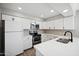 Modern kitchen with stainless steel appliances, white cabinets, and quartz countertops at 4737 E Belleview St, Phoenix, AZ 85008