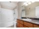 Bathroom featuring a shower-tub combo, single sink vanity, and wood cabinets at 5345 E Van Buren St # 308, Phoenix, AZ 85008