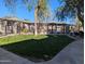 Community area featuring a pergola with seating, an iron fence, and beautiful green grass at 5345 E Van Buren St # 308, Phoenix, AZ 85008