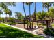 Outdoor grill and picnic area featuring lush green grass, mature trees, and blue sky at 5345 E Van Buren St # 308, Phoenix, AZ 85008