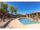 Community swimming pool with fountain, sun loungers, and pergola covered lounge area at 5345 E Van Buren St # 308, Phoenix, AZ 85008
