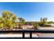 Balcony view of a landscaped entrance with mature shade trees and blue sky at 5345 E Van Buren St # 308, Phoenix, AZ 85008