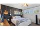 Stylish bedroom featuring dark accent wall, ceiling fan, and plentiful natural light at 5809 W Morten Ave, Glendale, AZ 85301