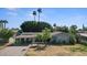 Charming single-story home featuring a covered carport, solar panels, and mature landscaping at 5809 W Morten Ave, Glendale, AZ 85301