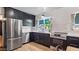 Modern kitchen featuring stainless steel appliances, dark cabinets, and a bright window at 5809 W Morten Ave, Glendale, AZ 85301