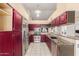 Updated kitchen featuring granite counters, stainless steel appliances, and custom red cabinetry at 607 W Palo Verde St, Gilbert, AZ 85233