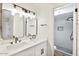Well-lit bathroom with double vanity, quartz countertop, modern black fixtures, and tiled walk-in shower at 8055 E Thomas Rd # A102, Scottsdale, AZ 85251