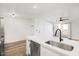 Bright open-concept kitchen with stainless steel appliances, white cabinets, and wood-style floors at 8055 E Thomas Rd # A102, Scottsdale, AZ 85251