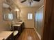 Bathroom with dark wood vanity, sink, mirror and walk-in shower with glass doors at 8269 E Desert Trl, Mesa, AZ 85208
