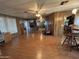 Spacious living room featuring wood paneling, ceiling fan, wood-look floors, and access to the kitchen and dining area at 8269 E Desert Trl, Mesa, AZ 85208
