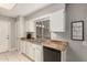 Well-lit kitchen with white cabinets, granite counters, and modern appliances at 9910 W Gulf Hills Dr, Sun City, AZ 85351