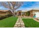 Charming home featuring a beautifully landscaped front yard with lush grass and a stone pathway at 10320 E Sunburst Dr, Sun Lakes, AZ 85248