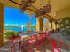 Inviting outdoor seating area with stylish red chairs, a long table, and serene lake views at 10320 E Sunburst Dr, Sun Lakes, AZ 85248