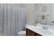 Bathroom with a shower-tub combo, a single sink vanity, tile flooring, and decorative fixtures at 10721 W Jefferson St, Avondale, AZ 85323