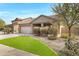 Attractive single-story home with desert landscaping, green grass, and a two-car garage at 10721 W Jefferson St, Avondale, AZ 85323
