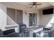 Covered patio with ceiling fan, comfortable seating, and a flatscreen television at 10721 W Jefferson St, Avondale, AZ 85323