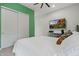 Modern bedroom with large TV, closet, and green accent wall at 11241 N Blakely St, Surprise, AZ 85388