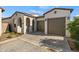 Inviting home featuring a two-car garage, arched entryways, and well-maintained landscaping at 11241 N Blakely St, Surprise, AZ 85388