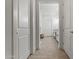 Hallway view leading to the bathroom with white cabinets, sink, and tile flooring at 11241 N Blakely St, Surprise, AZ 85388